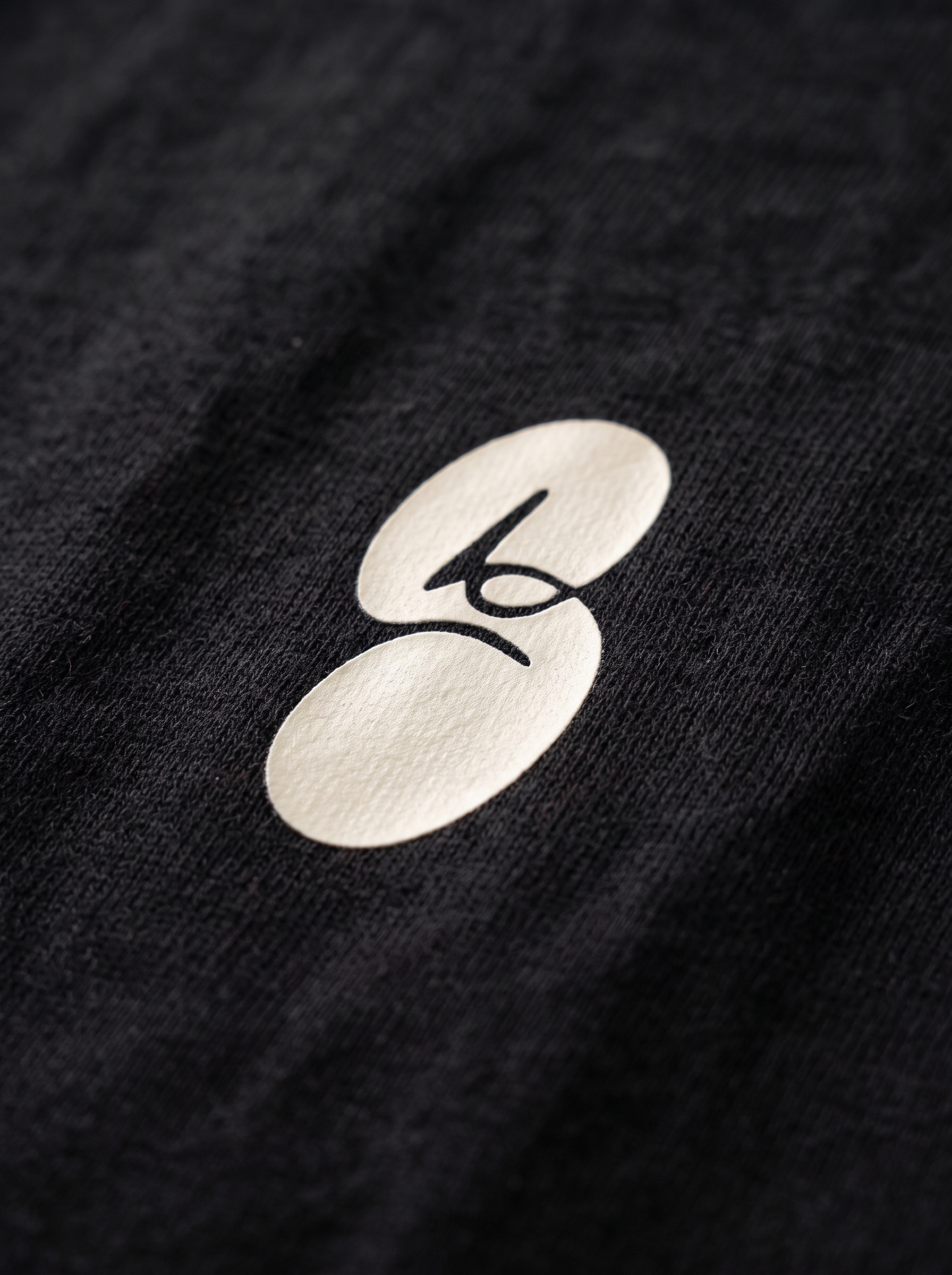 Close detail of the white STRAUM mark on combed cotton